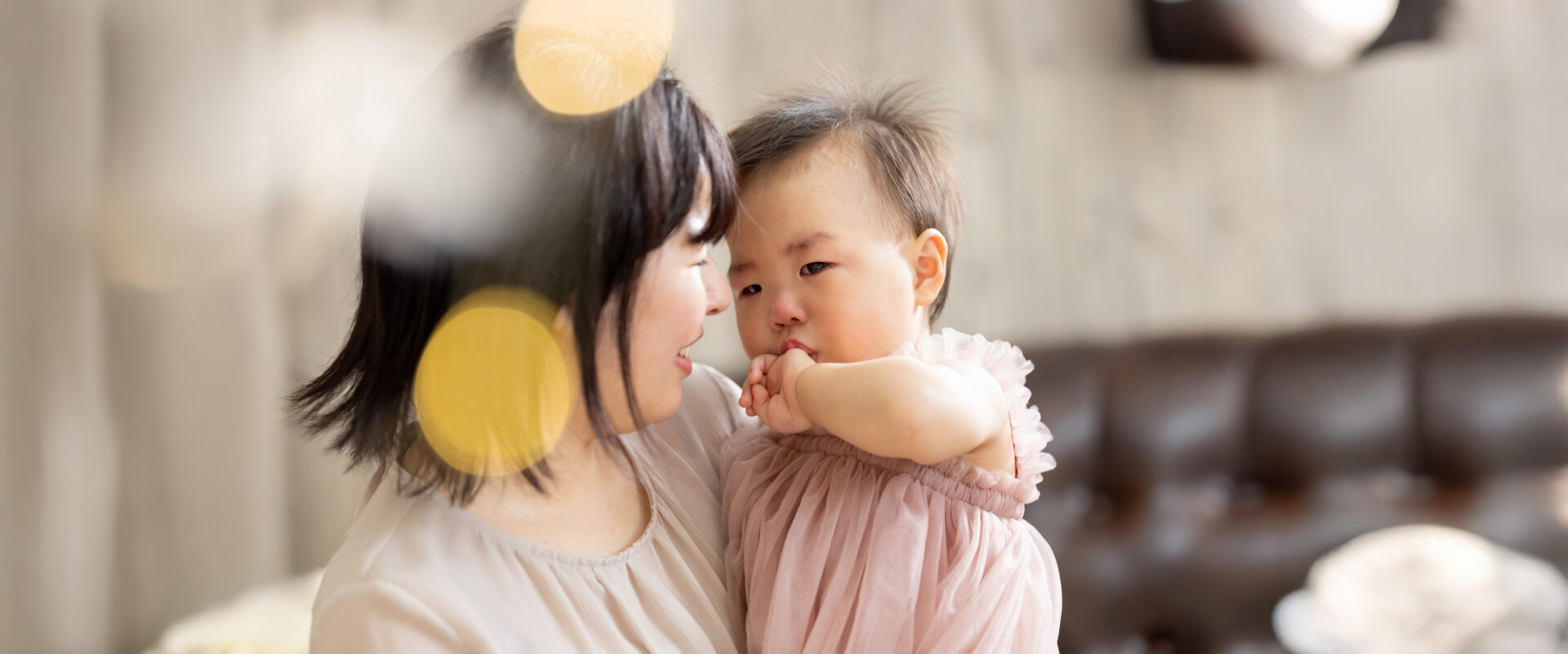 初めてのスタジオ撮影を前に、人見知りや場所見知りを心配しながらも優しくお子さんを抱きしめるパパママ