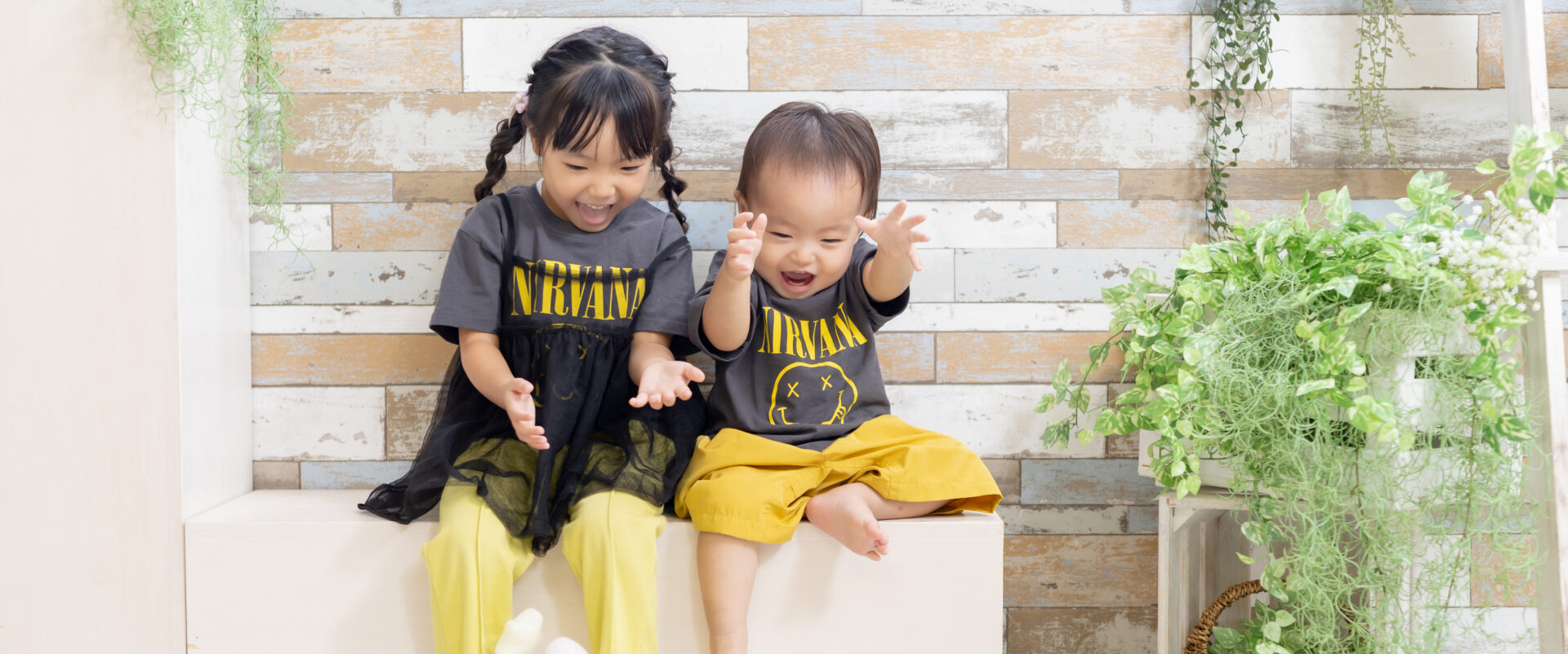 おめかしした可愛いお洋服を着て嬉しそうにつかまり立ちをする1歳の男の子