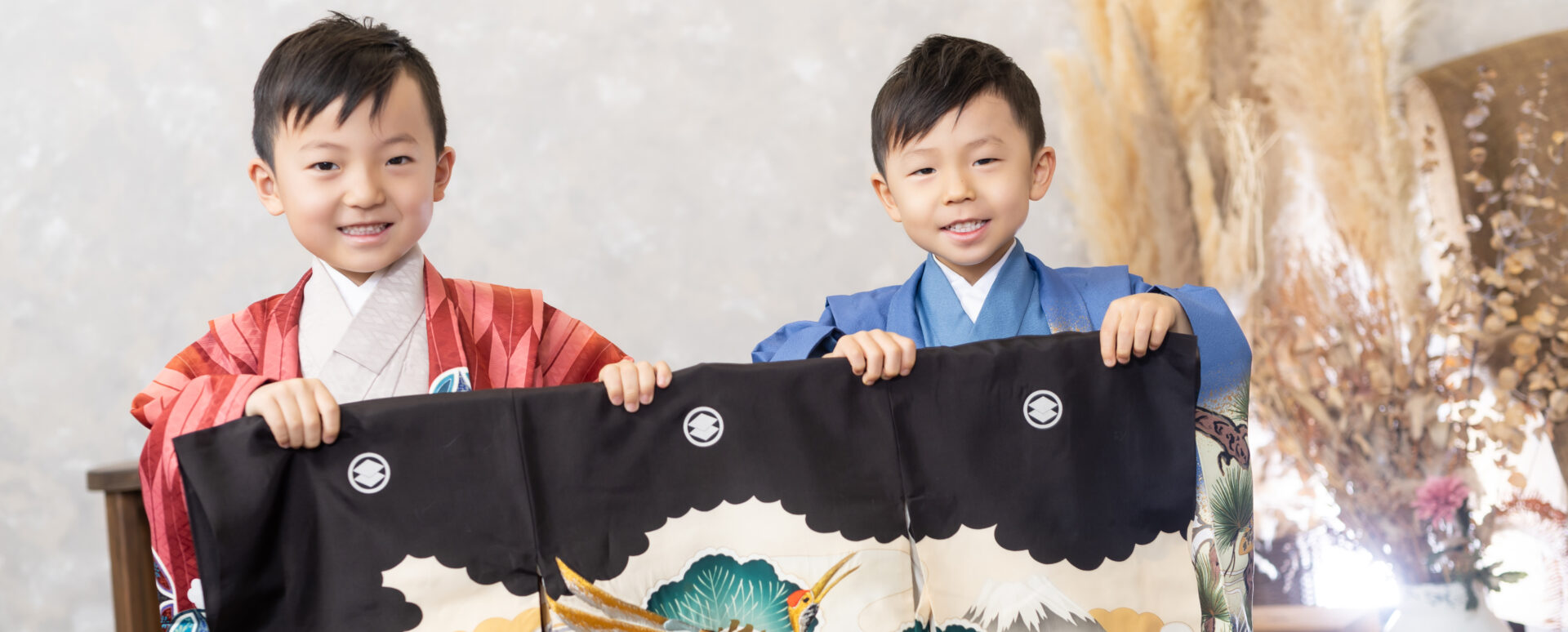 **代替テキスト:**
Photostudio PASSIONで、七五三の着物姿の男の子2人が一緒に笑顔を見せるスタジオ写真。