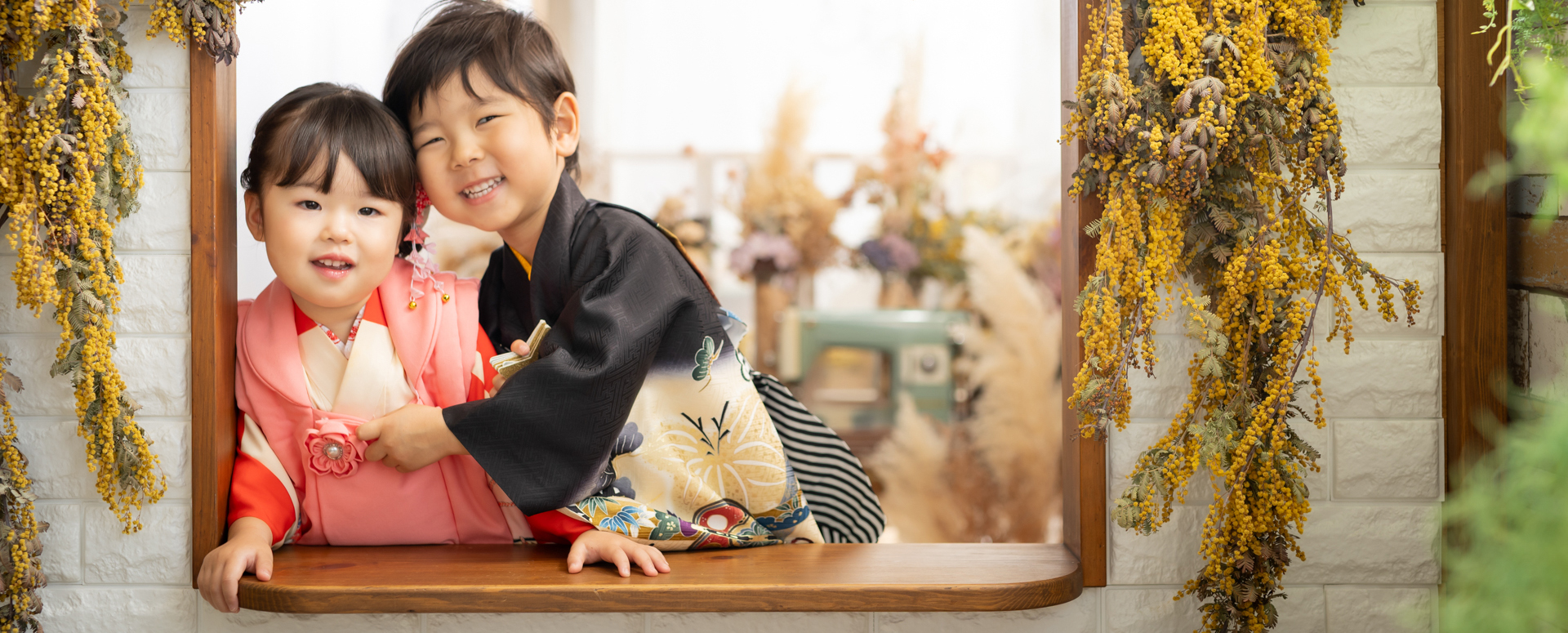 Photostudio PASSIONで、七五三の着物姿の兄妹が寄り添いながら笑顔を見せるスタジオ撮影。