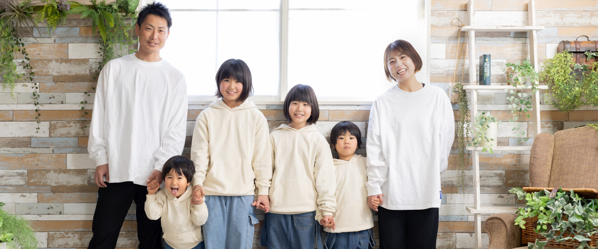 家族みんなで服装のトーンを美しく合わせ、温かい光に包まれてお洒落に写る家族写真
