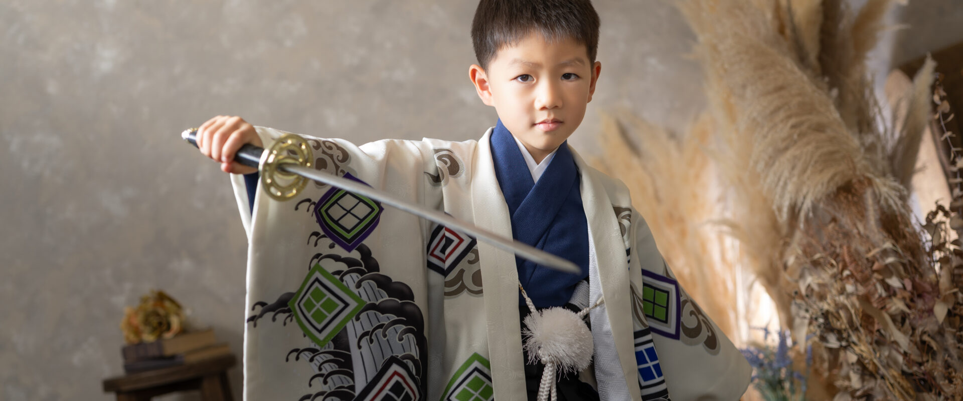 5歳の七五三を迎え、キリッと凛々しい羽織袴を身にまとって誇らしげに微笑む男の子