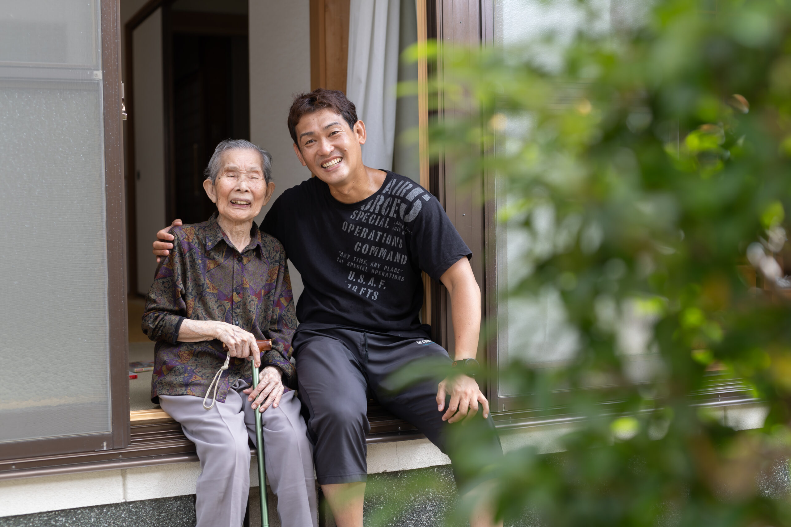 笑顔で寄り添う母と成人した息子の家族写真