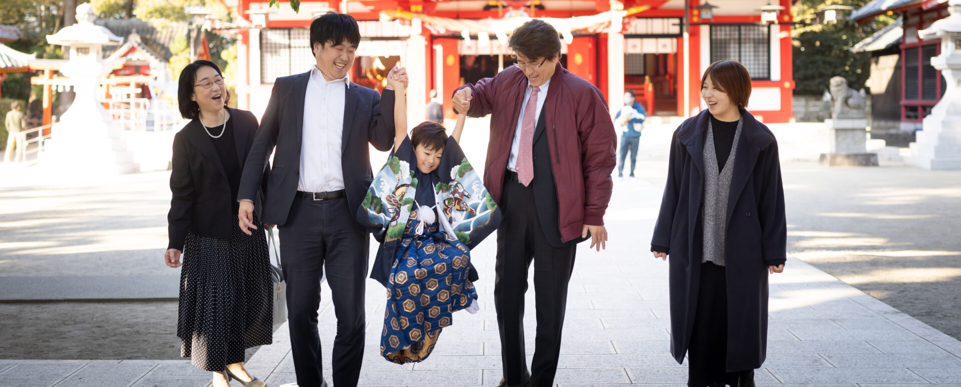 大分市の春日神社で七五三のお参りをする男の子。家族と手をつなぎながら過ごす自然な姿を撮影した記念写真。