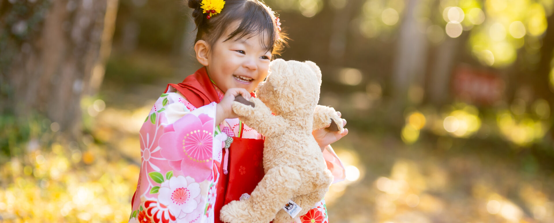 大分市の西寒多神社で七五三のお参りをする女の子。着物姿でお気に入りのぬいぐるみを抱き、楽しそうな笑顔を見せる記念写真。