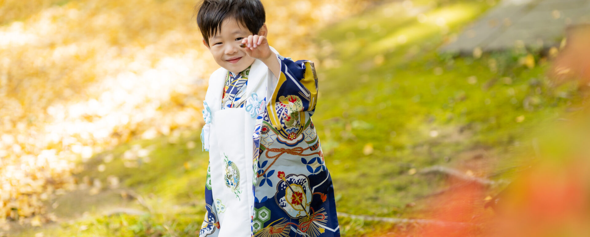 大分市の西寒多神社で七五三のお参りをする男の子。色鮮やかな着物姿で、秋の境内を楽しそうに歩く自然な記念写真。