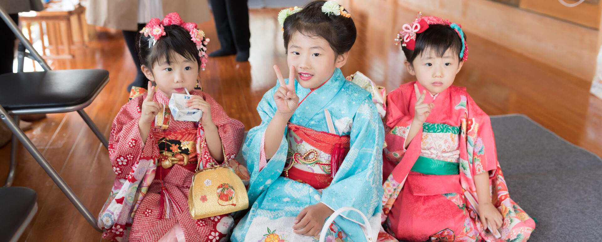 別府市の八幡竈門神社で七五三のお参りをする着物姿の3人の女の子。ご祈願を終え、仲良く並んで笑顔を見せる七五三写真。