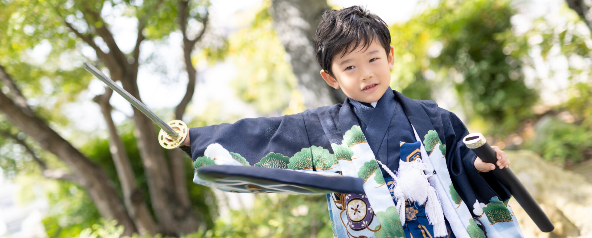 大分市の若宮八幡社で七五三のお参り撮影をする男の子。着物姿で刀を持ち、楽しそうにポーズを決める記念写真。