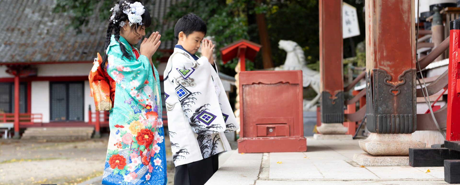 別府市の朝見神社で七五三のお参りをするきょうだい。着物姿で並び、拝殿に向かって一緒に手を合わせる記念写真。