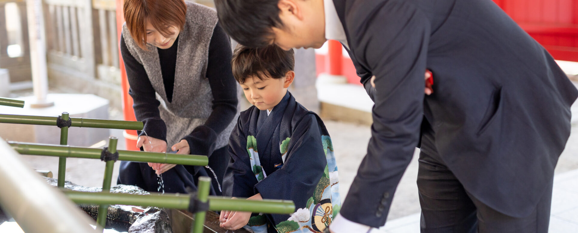 大分市の春日神社で七五三のお参りをする男の子。家族と一緒に手水舎で手を清める様子。