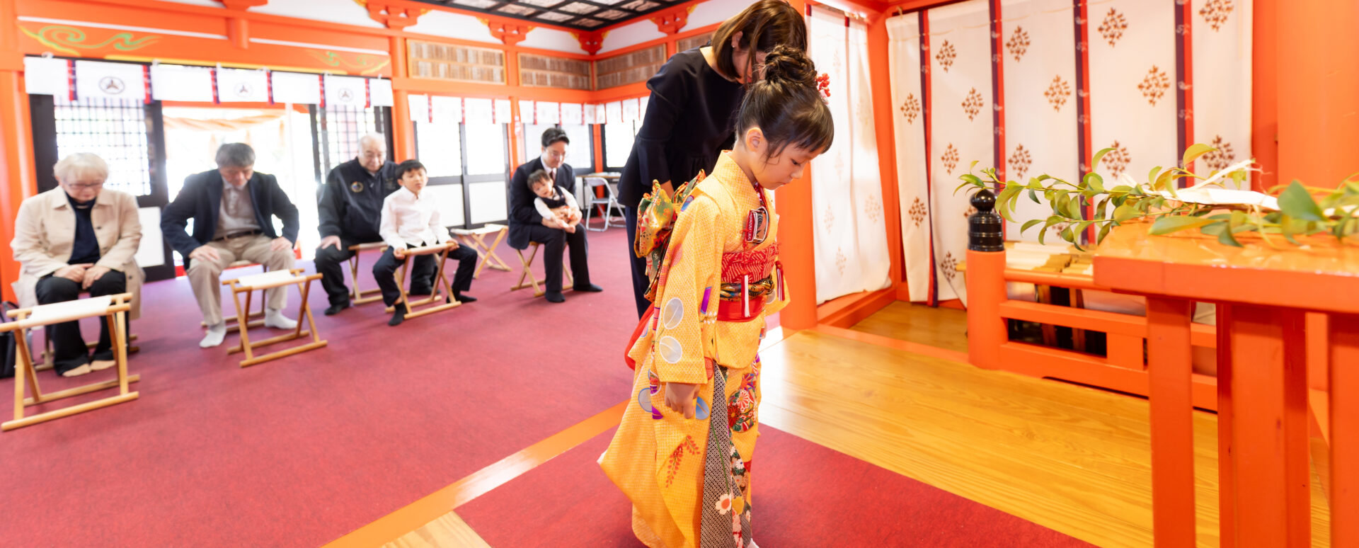 大分市の若宮八幡社で七五三のご祈祷を受ける女の子。家族が見守る中、祭壇の前でお参りをする様子を撮影した一枚。