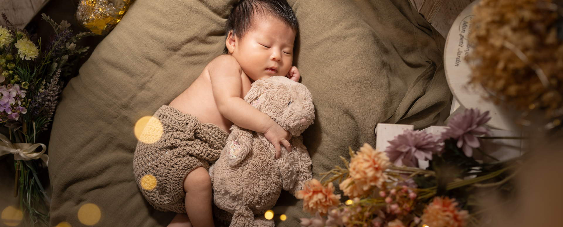 大分のPhotostudio PASSIONで撮影したニューボーン風フォト。うさぎのぬいぐるみを抱きながら、すやすや眠る赤ちゃんの自然な姿を撮影した一枚。