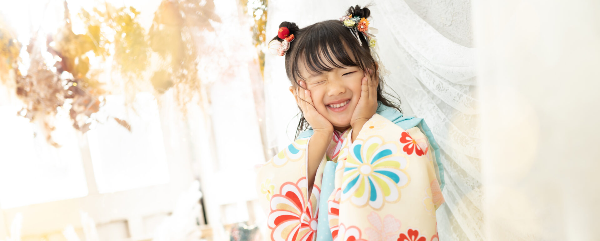 大分のPhotostudio PASSIONで、華やかな着物姿で頬に手を添えて笑顔を見せる7歳七五三のスタジオ撮影