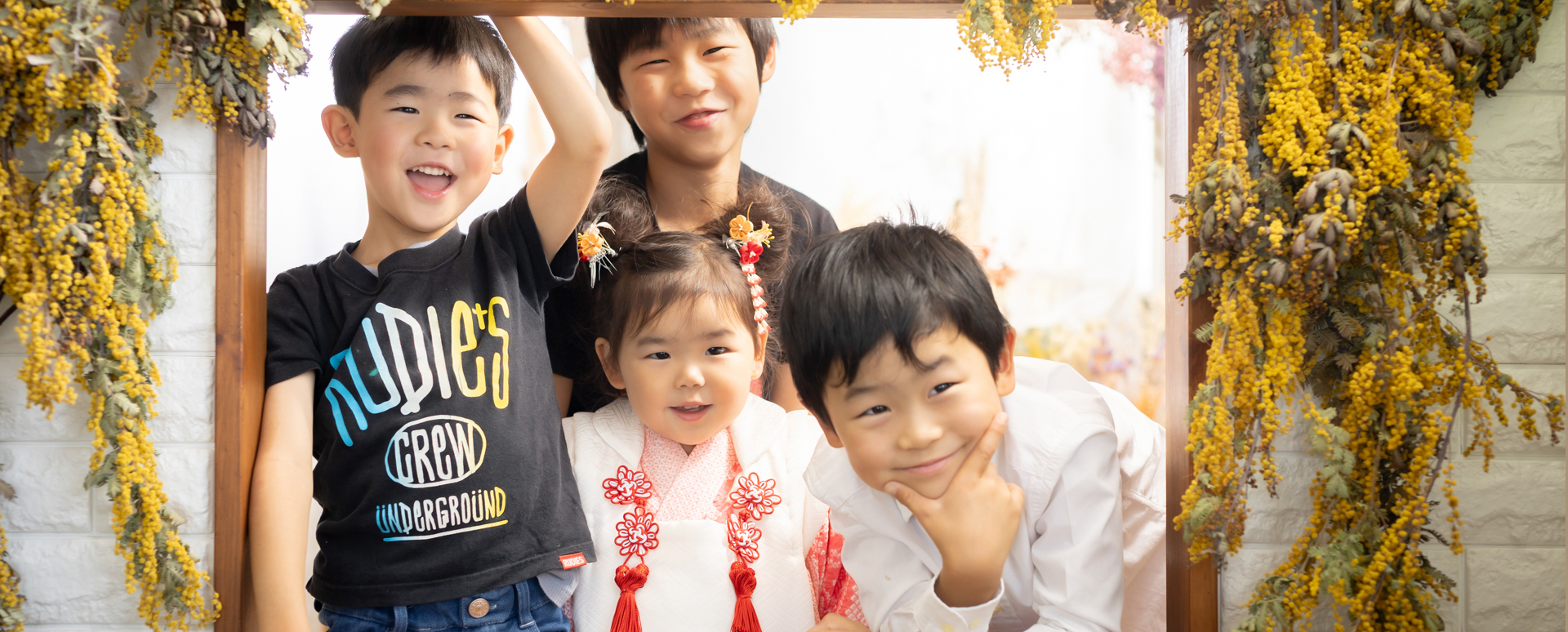 大分のPhotostudio PASSIONで、3歳七五三の女の子を囲んで楽しそうな表情を見せる兄弟姉妹のスタジオ撮影
