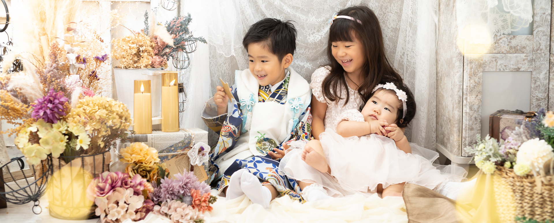 大分のPhotostudio PASSIONで、七五三の着物姿の男の子とドレス姿の姉妹が仲良く過ごすきょうだい写真