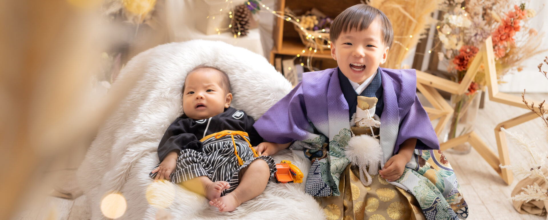 大分のPhotostudio PASSIONで、紫の羽織袴姿の七五三の男の子と和装の赤ちゃんを一緒に撮影した兄弟写真